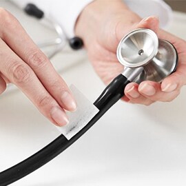 A Littmann fonendoszkóp csöveit alkoholos törlőkendővel tisztító kéz.