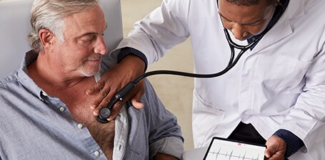 Egy férfi mellkasához 3M Littmann CORE digitális fonendoszkópot tartó klinikus
