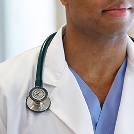 Littmann fonendoszkóp megfelelően, a fehér köpeny gallérján kívül viselve, amely megakadályozza, hogy a csövek hozzáérjenek a szakember nyakához.